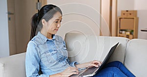 Woman work on computer and sit on sofa