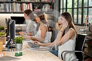 Woman work with other co-workers in office as teamwork of operator or call center