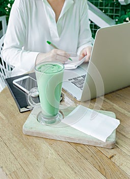 Woman work place cafe terassa freelancer PC laptop summer white matcha cup coffee tea