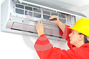 Woman worker adjusting air conditioner system