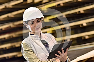 Woman worker checking on quality production in warehouse
