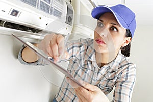 Woman worker inspecting air conditioning system