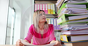 Woman worker overloaded with tasks in folders in office