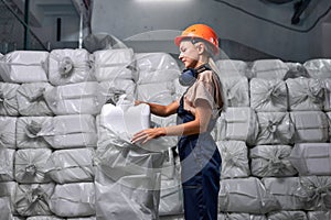 Woman worker in protective uniform working in pesticides production factory