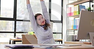 Woman worker stretches hands and arms before wrapping up task