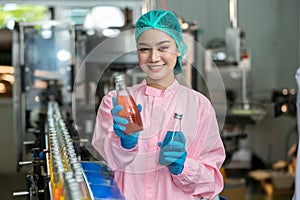 Woman worker using Checking quality or checking stock of products in beverage factory. Worker QC working in a drink water factory