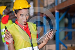 Woman worker using tablets and checks goods in the automotive parts warehouse distribution center. Female engineers people wear a