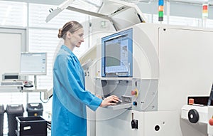 Woman worker at visual inspection of PCB on electronics assembly line