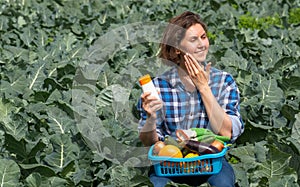 Woman working on an agricultural field during a sunny day and protecting her skin from the sun with sunscreen