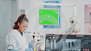 Woman working as dentist with green screen and x ray scan