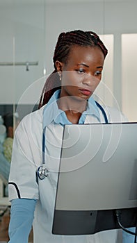 Woman working as doctor with stethoscope using computer