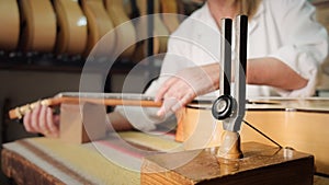 Woman Working As Lute Maker Tuning Guitar With Diapason