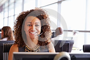 Woman working in a call centre, looking to camera, close-up