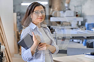 Woman working in carpentry, industrial portrait. Female in woodworking workshop