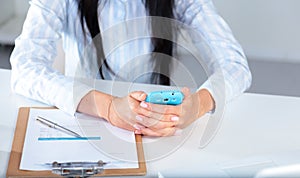 Woman working on celphone, sitting at the desk