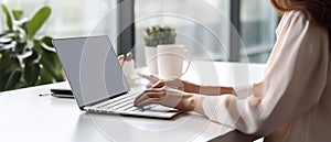 Woman working on computer in modern office, close up. Woman hands typing on keyboard of laptop, online shopping detail