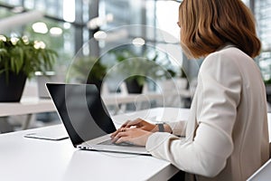 Woman working on computer in modern office, close up. Woman hands typing on keyboard of laptop, online shopping detail