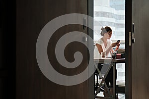 Woman Working In Corporate Office Sending Email With Phone