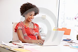 Woman Working In Design Studio Having Lunch At Desk