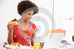 Woman Working In Design Studio Having Lunch At Desk