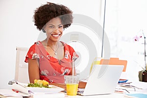 Woman Working In Design Studio Having Lunch At Desk