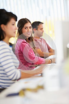 Woman Working At Desk In Busy Creative Office