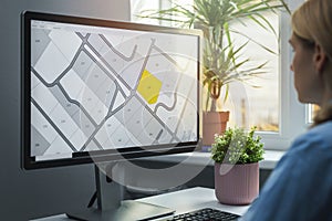 Woman working with digital land registry database on computer in office photo