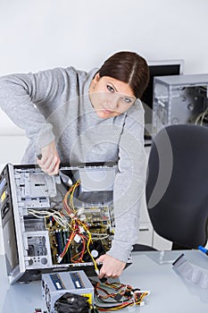 Woman working on dismantled computer