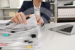 Woman working with documents at table in office, closeup