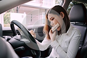 Woman working and eating at the wheel in the car, Busy woman is in a hurry