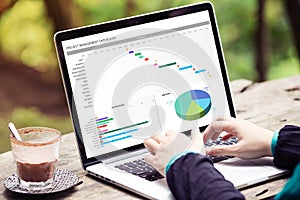 Woman working with excel project dashboard on laptop / computer