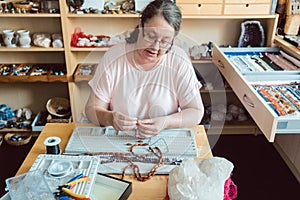 Woman working on a gemstone necklace as a hobby