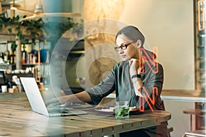 Woman working on her laptop at a cafe. Caucasian woman with glasses sitting at a cafe and working on her laptop