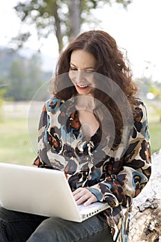 Woman working on her laptop in a park.