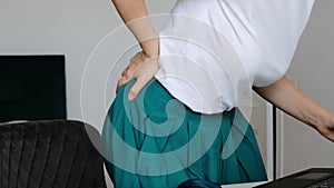 Woman working his computer suddenly she feeling pain in back and waist. Close up