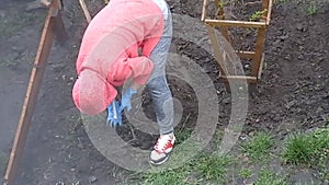 Woman working with a hoe in the garden