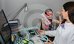 Woman working from home with her daughter interrupting her