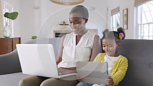 Woman working from home while her daughter using digital tablet