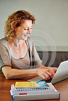 Woman working from home on laptop smiling