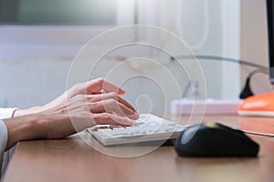 Woman working at home office hand on keyboard close up