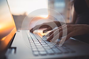 Woman working at home office hand on keyboard close up