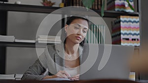 Woman working from home using laptop computer while reading text message. woman using laptop work study in office