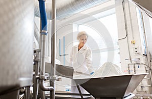 Woman working at ice cream factory conveyor