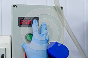 Woman working in industry, adjusting tank thermostat photo