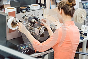 Woman working on label printing machine