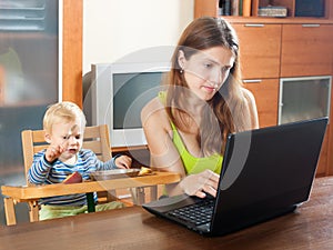 Woman working with laptop and baby