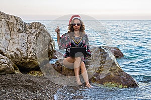 Woman working on laptop on the beach, christmas weekend