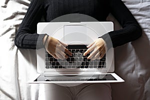 Woman working with the laptop in bed