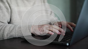 woman working on a laptop, close-up without a face