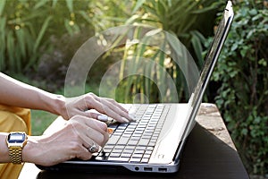 Woman working on laptop close up. sitting outdoor.